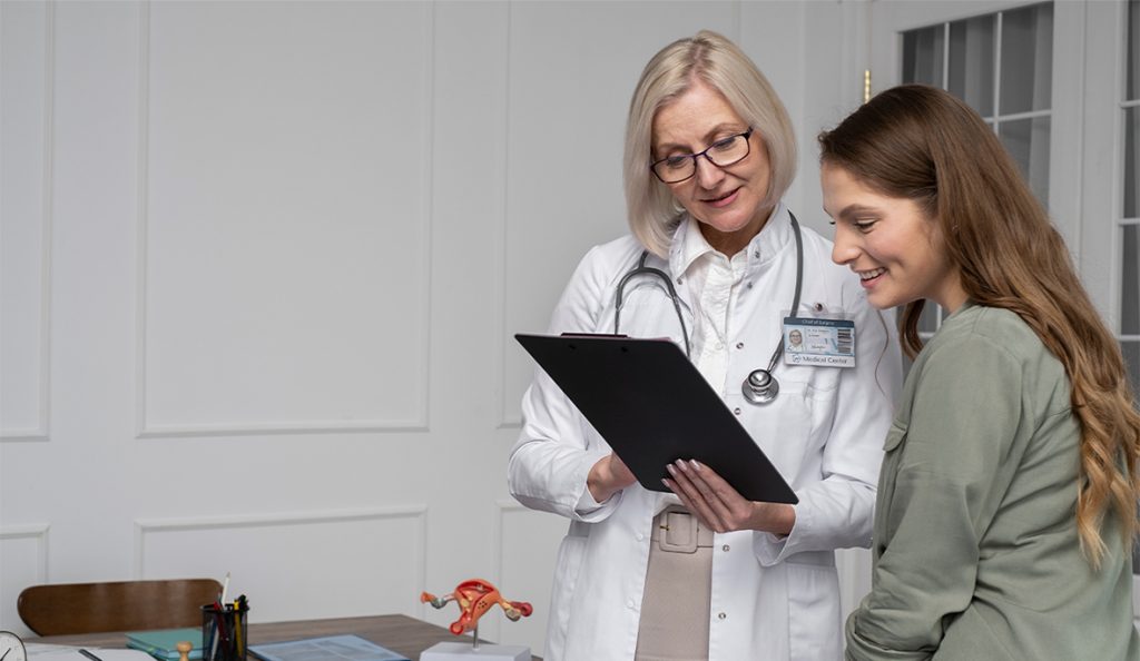 A doctor reviews on-site testing and procedures results on a clipboard with a smiling patient in a medical office.