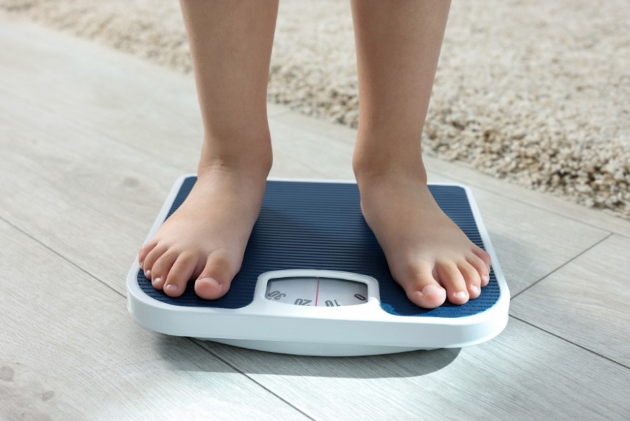 Patient tracking progress on a scale during a preventive and wellness care in Houston weight management consultation.