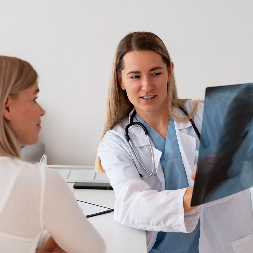 Male doctor in white coat checking a senior woman's blood pressure during an Annual & Work Physicals Houston TX exam.