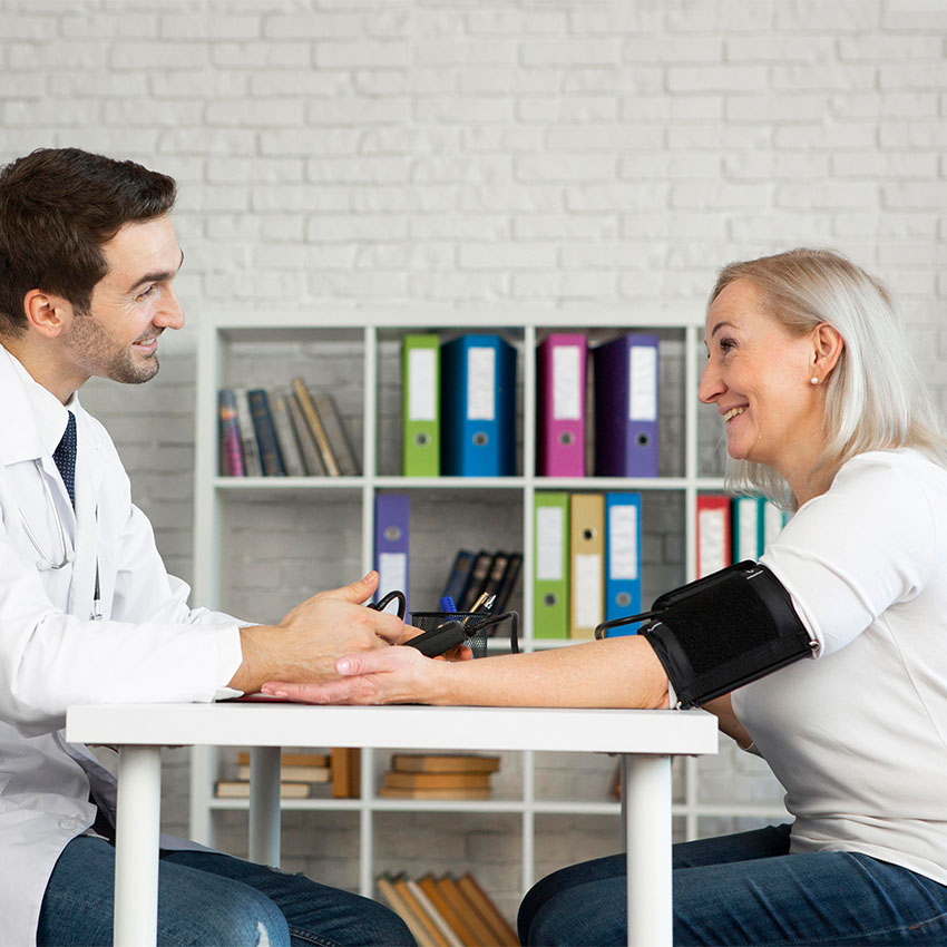 A female doctor discusses an X-ray with a patient during a comprehensive Annual & Work Physicals Houston TX exam.